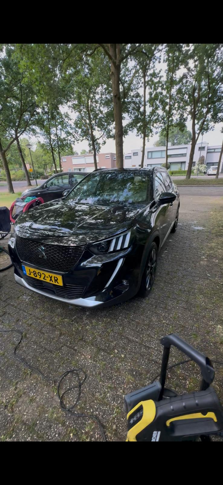 Zwarte Peugeot 2008 tijdens een wasbeurt op locatie