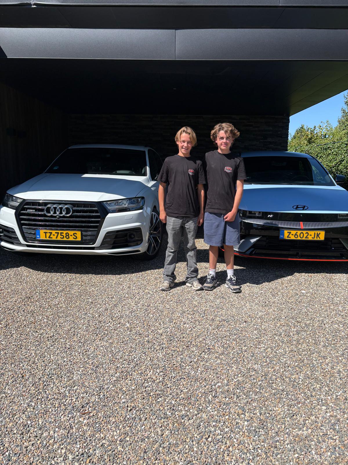 Wij tweeën naast twee auto's die we net hebben gewassen